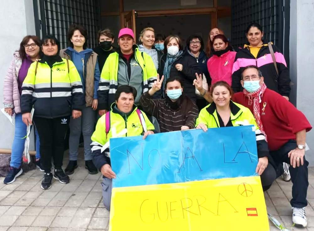 Grupo de voluntarios con bandera de Ucrania y no a la guerra