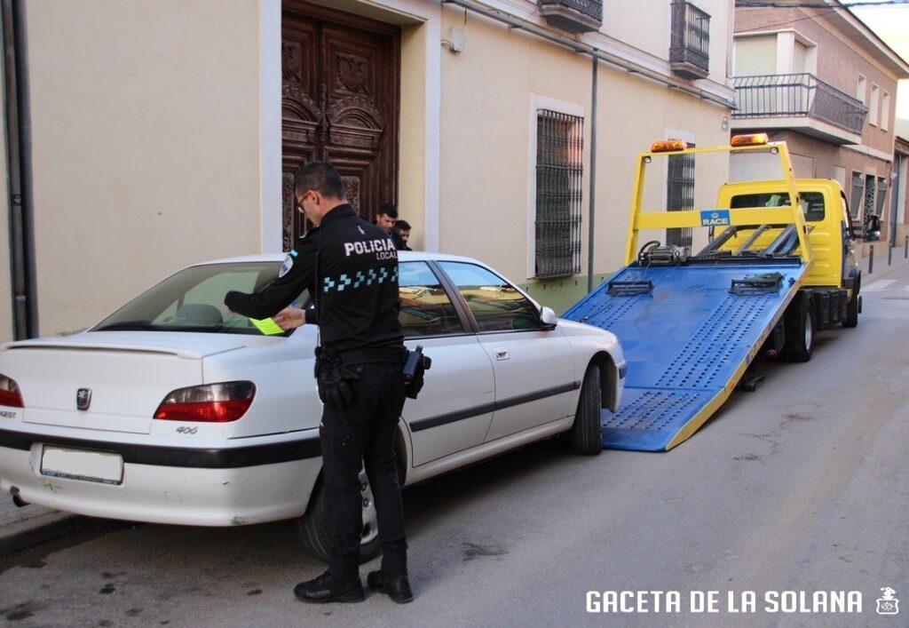Grúa retira un coche el Jueves Santo en la calle Carrera