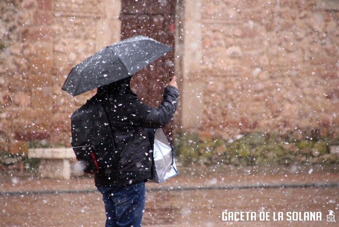 Un hombre filma con su móvil la nevada en mitad de la Plaza Mayor