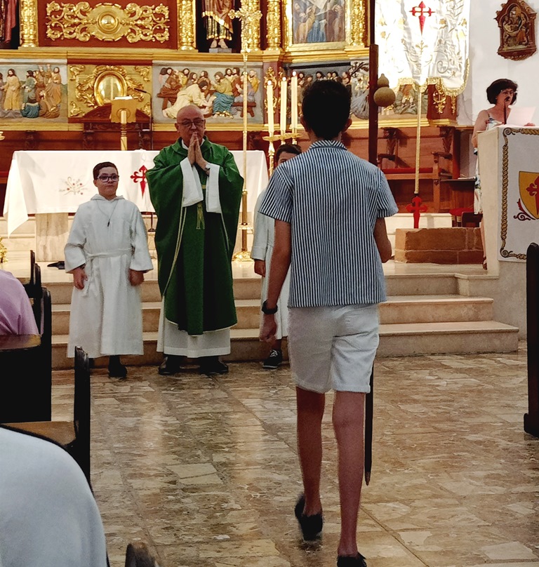 -Adolescente se dirige a entregar el bordón de peregrino