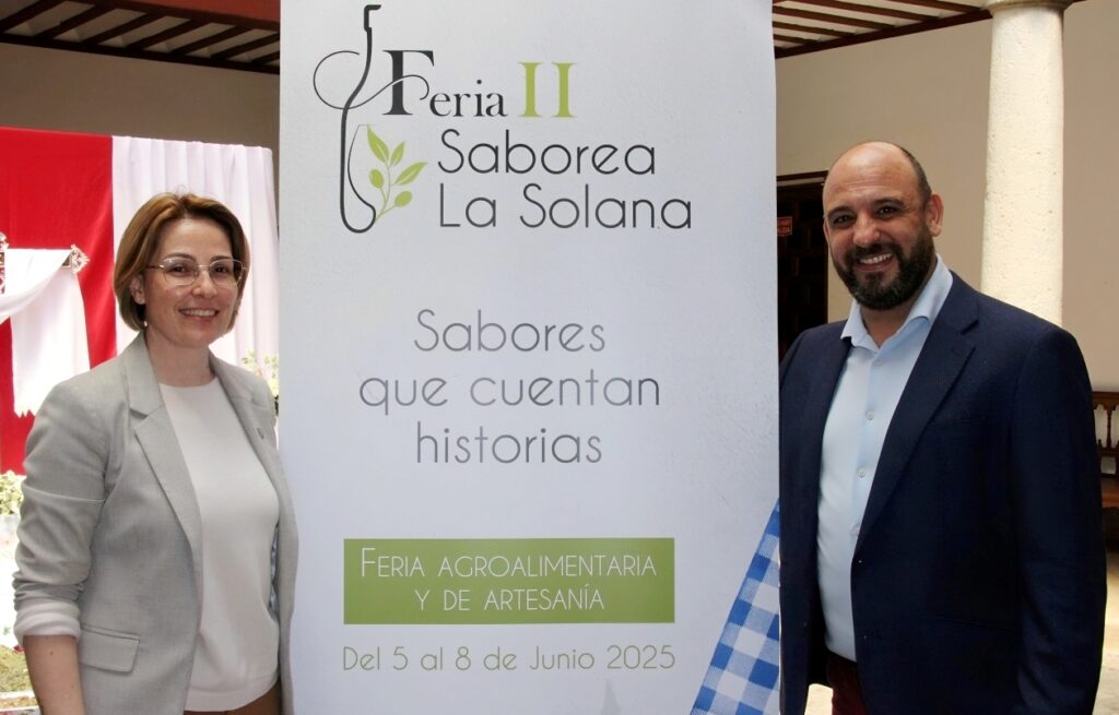 -Luisa Márquez y Santiago López junto al cartel de la feria agroalimentaria